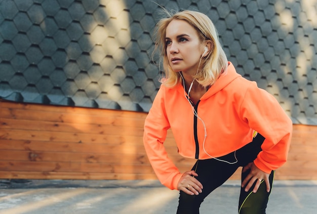 Foto persona giovane bella donna che ascolta musica che corre jogging in strada della città