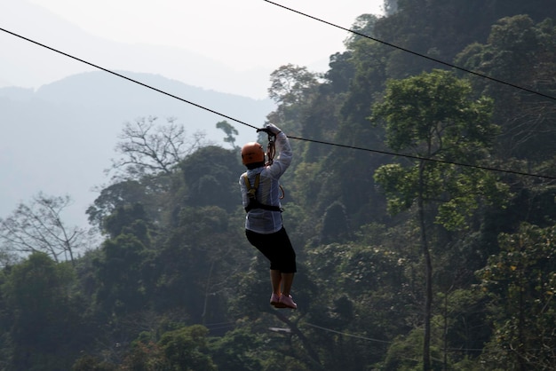 Photo person on zip line against tree mountains