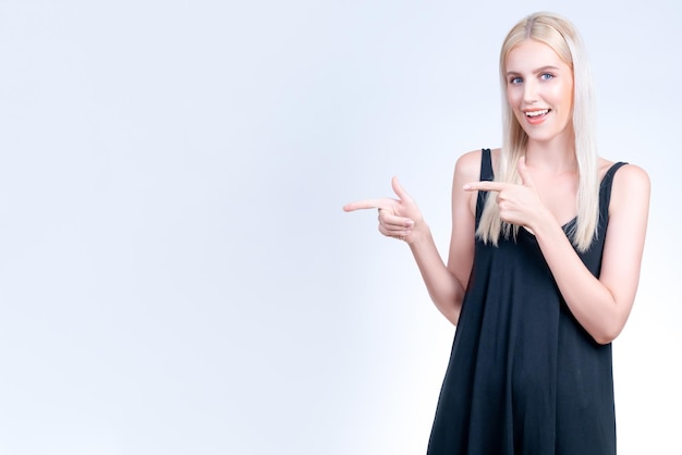 Personable woman pointing finger advertising product in isolated background