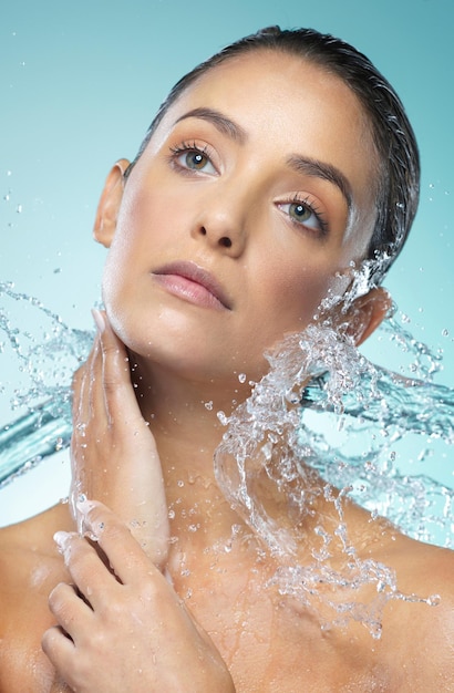 Personal hygiene is essential for maintaining good relationships with others Shot of a young woman taking a shower against a blue background