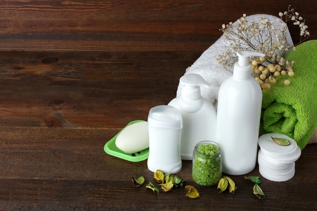 Personal hygiene items with decorative sprigs on a brown wooden background