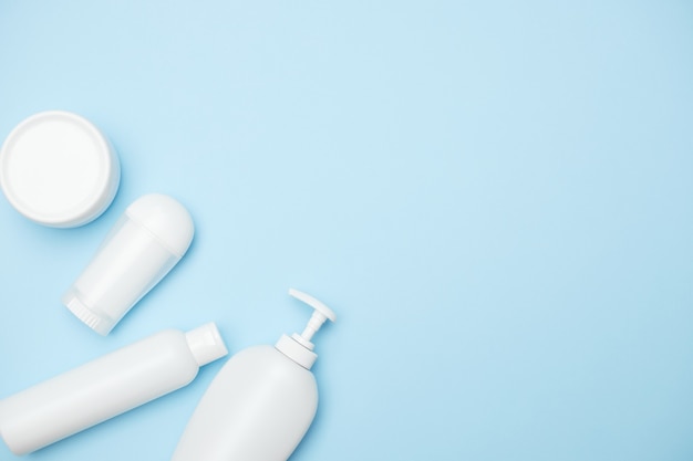 Personal hygiene product white jars on a blue background, copy space, top view. High quality photo