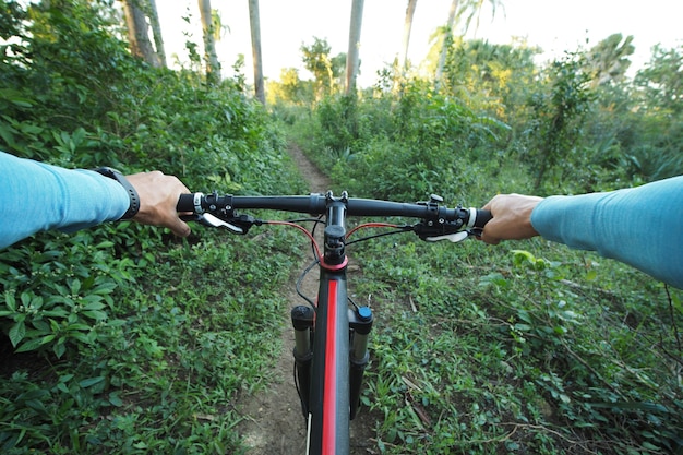 写真 熱帯環境で自転車に乗る男の個人的な視点のショット