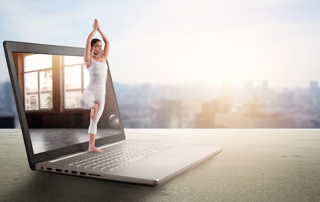 Personal trainer does gym lesson of yoga through internet and laptop