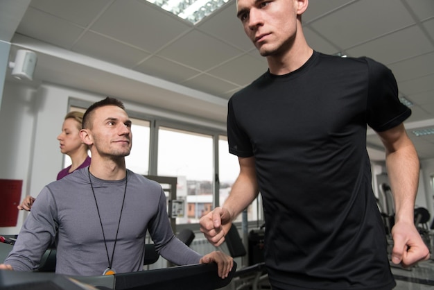 Personal Trainer en cliënt in sportschool op loopbanden