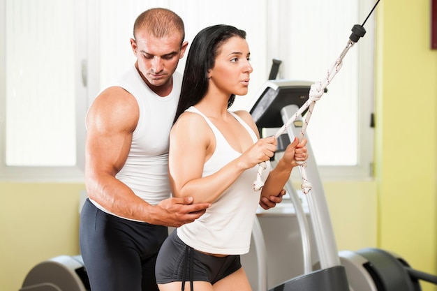 Personal trainer giving instructions a woman in gym