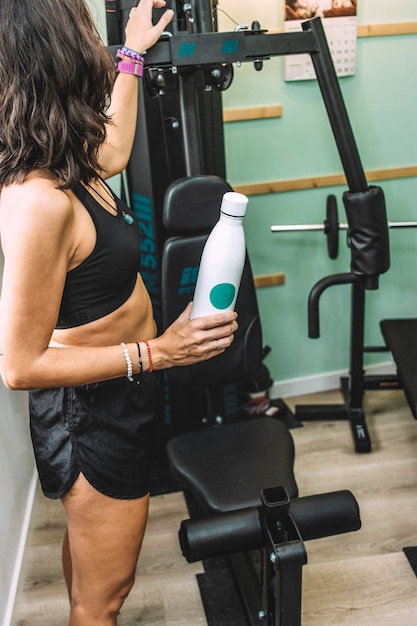 Foto personal trainer che riposa accanto alla stazione di allenamento