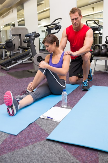 Personal trainer rubbing clients shoulders on mat