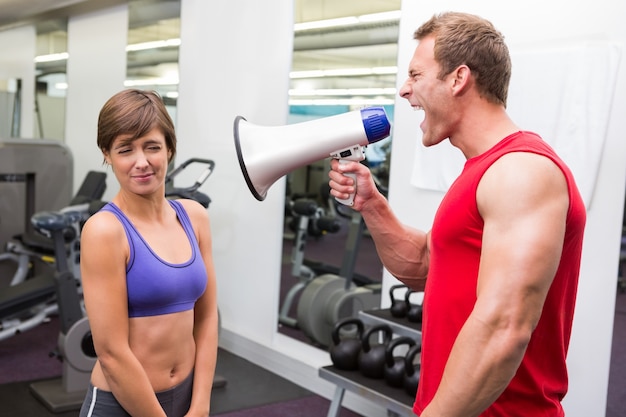 Personal trainer shouting at client through megaphone