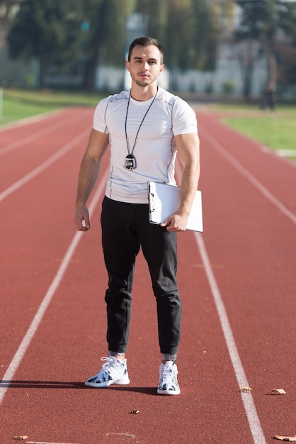 Personal Trainer In Sports Outfit Takes Notes On Clipboard in City Park Area  Training and Exercising for Endurance  Healthy Lifestyle Concept Outdoor