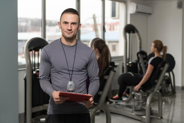 Foto il personal trainer prende appunti mentre la donna esercita le gambe