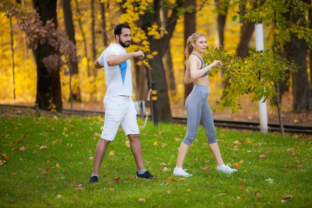 Personal trainer takes notes while woman exercising outdoor