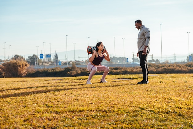 Personal trainer training a girl outside