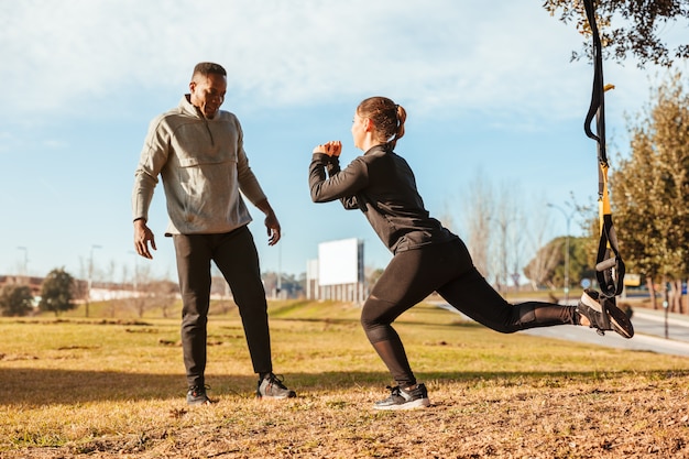 Photo personal trainer training a girl on the outside