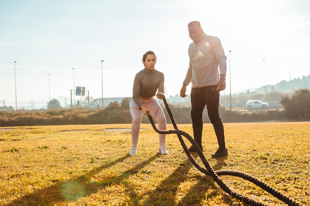 Personal trainer training a girl with ropes