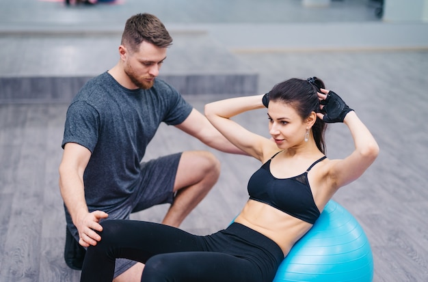 Personal trainer training his client in the gym.