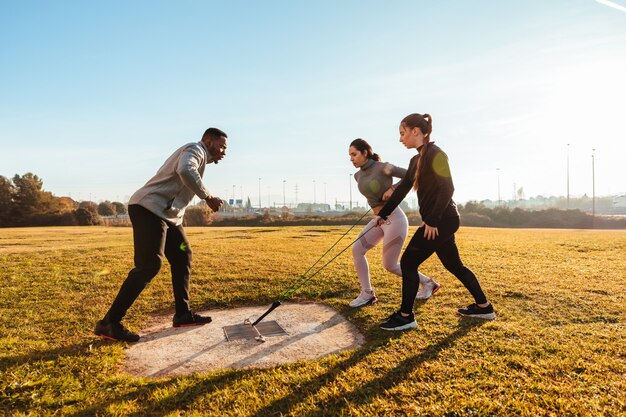 Personal trainer training two girls outdoor