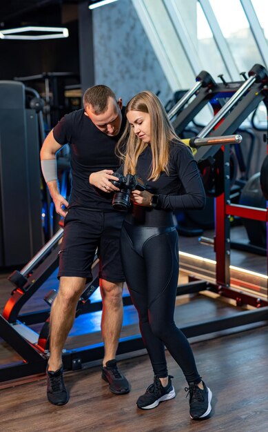Photo personal trainer and young woman in the gym