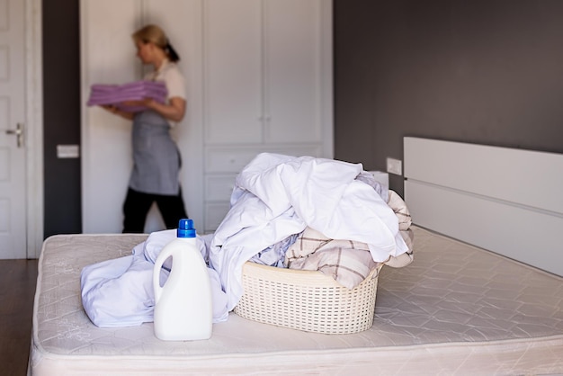 Personeel maakt de hotelkamer schoon verandert beddengoed Vloeibaar wasmiddel mockup