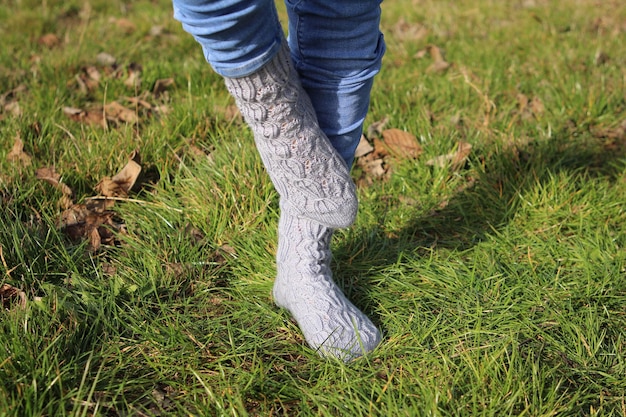 Foto le gambe di una persona in jeans e stivali nell'erba