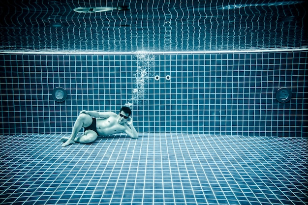 Photo persons lies under water in a swimming pool