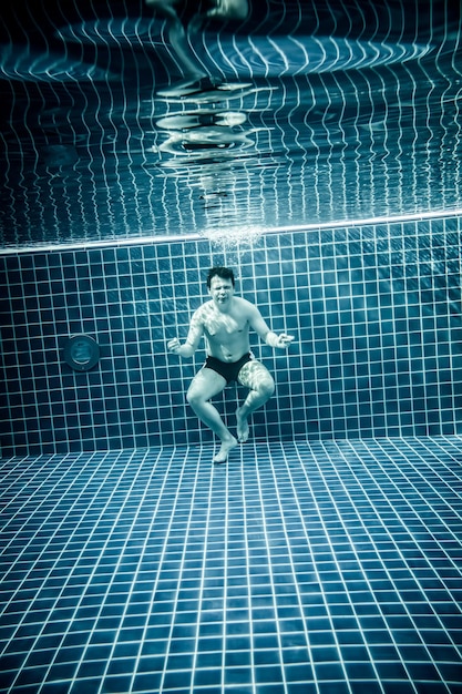 Persons standing under water in a swimming pool