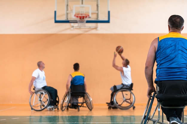 Persons with a disability in wheelchairs playing a match in a\
sports gym hall. concept sport for persons with a disability.\
selective focus. high-quality photo