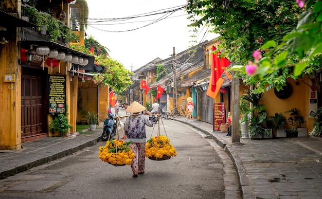 Foto persoon die bloeiende bloemen draagt langs een straatfoto