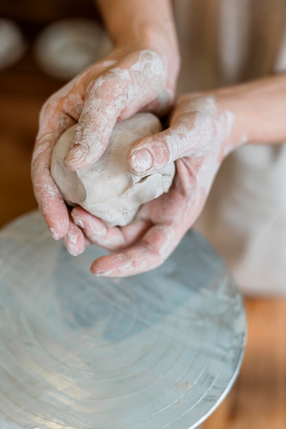 Persoon die een aarden pot maakt in haar atelier