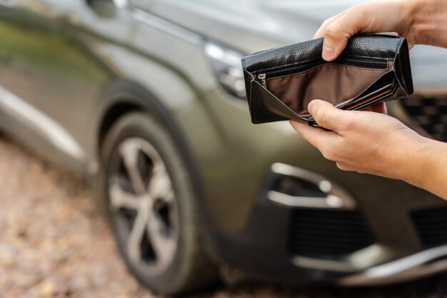 Persoon die een lege portemonnee in de handen houdt, staat voor auto Verzekeringslening en autoconcept kopen