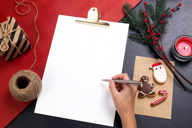 Foto persoon die een nota met smakelijke kerstmis eigengemaakte koekjes schrijft