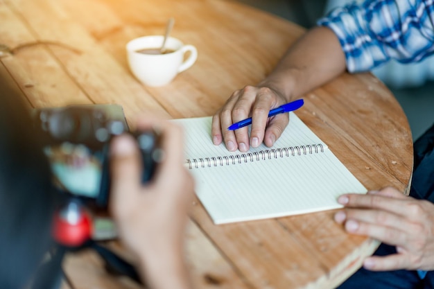 Foto persoon die fotografeert terwijl man op boek schrijft