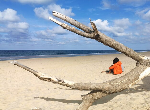 Foto persoon die in de open lucht rust ontspannen op het strand in de herfsteenzaamheid