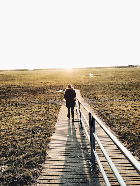 Foto persoon die op de promenade loopt tegen een heldere hemel