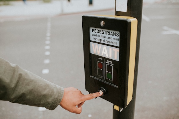 Persoon die op een voetgangerskruisdrukknop drukt