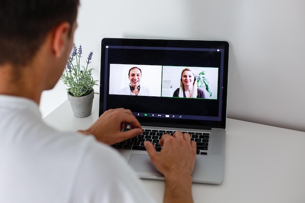 Persoon die videoconferentietechnologie gebruikt in de keuken voor videogesprekken met collega's thuis en op kantoor