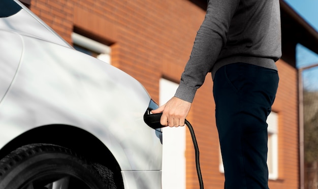 Persoon die voor elektrische auto zorgt