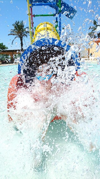 Foto persoon die water spat in een glijbaan in het park