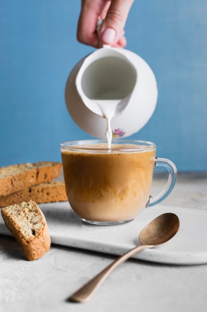 Foto persoon gieten melk in glas met koffie