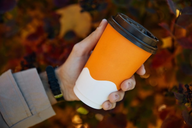 Foto persoon houdt kopje koffie en geniet van herfstweekenden