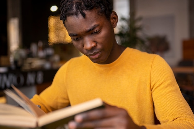 Foto persoon in een café die een boek leest