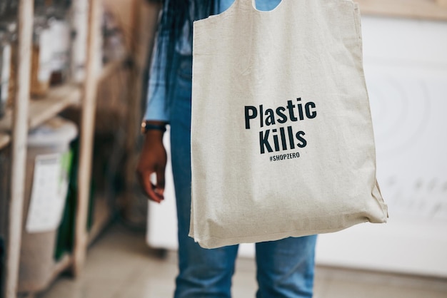 Persoon in een milieuvriendelijke supermarkt recycling boodschappenzak en toewijding aan klimaatverandering bij duurzame kleine bedrijven Zero plastic afval doodt logo en supermarkt koolstofvoetafdruk keuze