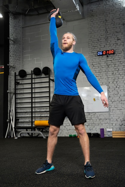 Foto persoon in sportgymnastiek die kettlebells gebruikt