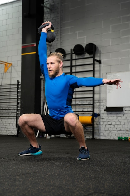 Persoon in sportgymnastiek die kettlebells gebruikt