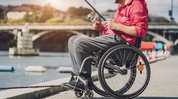 Persoon met een lichamelijke beperking in een rolstoel vissend vanaf vissteiger