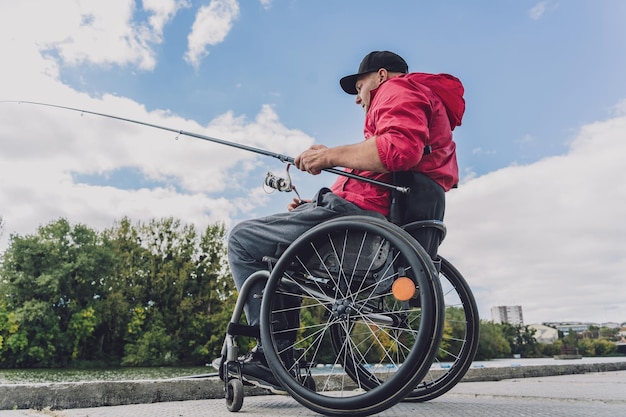 Persoon met een lichamelijke beperking in een rolstoel vissend vanaf vissteiger