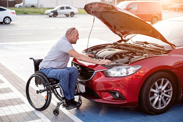 Persoon met een lichamelijke handicap check motor zijn auto op parking