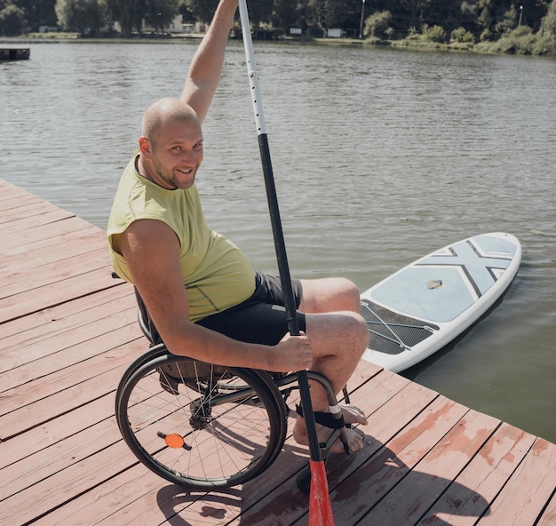 Persoon met een lichamelijke handicap die een rolstoel gebruikt, rijdt op sup board