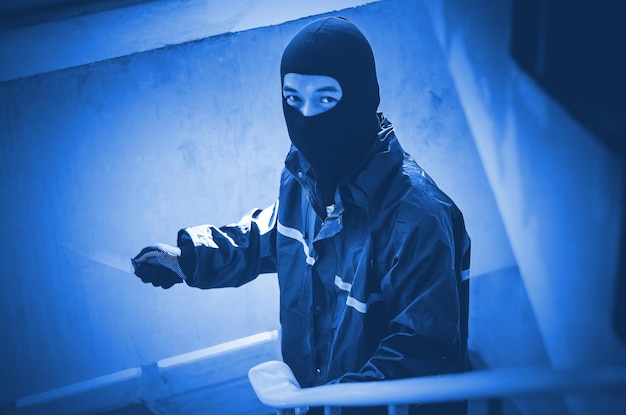 Foto persoon met een masker tegen een blauwe muur