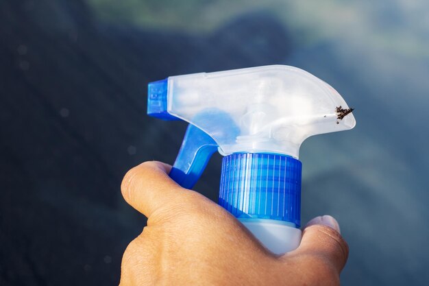 Foto persoon met een plastic fles met een insect erop duim op de trekker